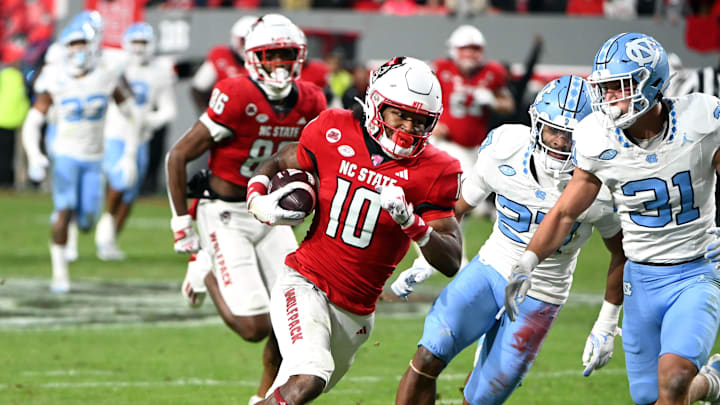 Nov 25, 2023; Raleigh, North Carolina, USA; North Carolina State Wolfpack receiver KC Concepcion (10) runs after a catch against North Carolina Tar Heels defensive back Will Hardy (31) during the first half at Carter-Finley Stadium. Mandatory Credit: Rob Kinnan-Imagn Images