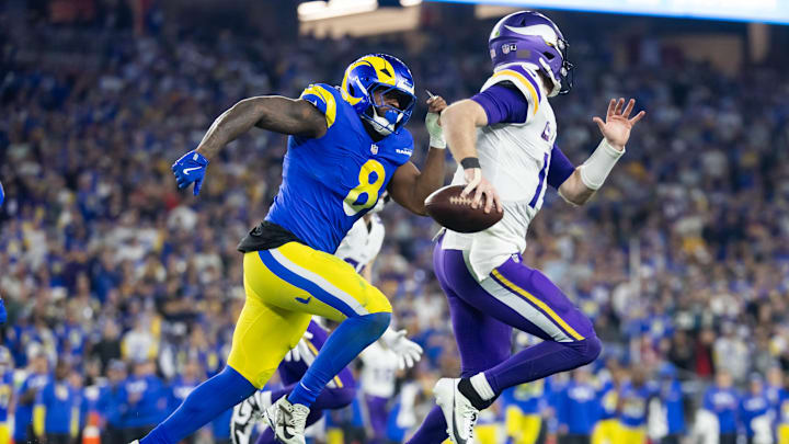 Jan 13, 2025; Glendale, AZ, USA; Minnesota Vikings quarterback Sam Darnold (14) is pursued by Los Angeles Rams linebacker Jared Verse (8) during an NFC wild card game at State Farm Stadium. Mandatory Credit: Mark J. Rebilas-Imagn Images Jan 13, 2025; Glendale, AZ, USA; Minnesota Vikings quarterback Sam Darnold (14) is pursued by Los Angeles Rams linebacker Jared Verse (8) during an NFC wild card game at State Farm Stadium. Mandatory Credit: Mark J. Rebilas-Imagn Images