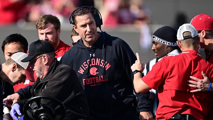 Nov 15, 2025; Bloomington, Indiana, USA; Wisconsin Badgers head coach Luke Fickell stands in the crowd surrounding an injured Wisconsin Badgers running back Gideon Ituka during the second half against the against the Indiana Hoosiers at Memorial Stadium. Mandatory Credit: Marc Lebryk-Imagn Images