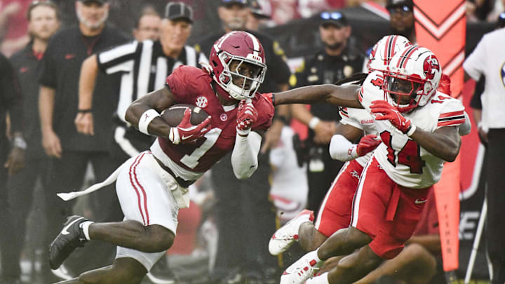 Aug 31, 2024; Tuscaloosa, Alabama, USA;  Alabama Crimson Tide wide receiver Kendrick Law (1) runs the ball for a touchdown against Western Kentucky Hilltoppers safety Devonte' Mathews (14) during the first half at Bryant-Denny Stadium.  Mandatory Credit: Gary Cosby Jr.-Imagn Images