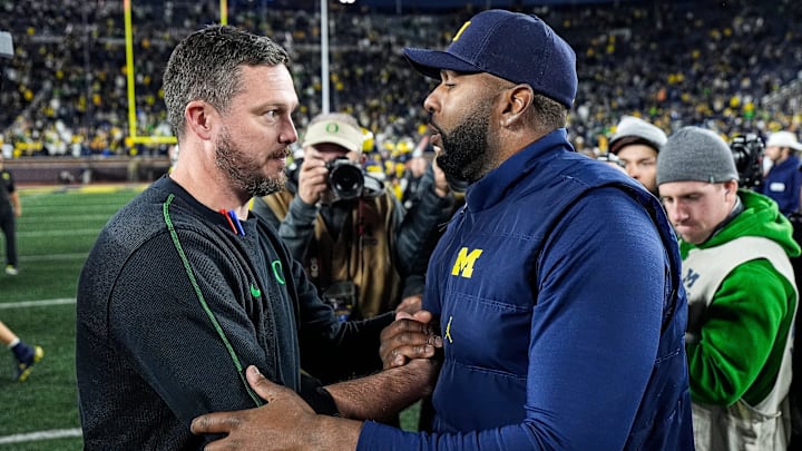 Michigan head coach Sherrone Moore, right, shakes hands with Oregon head coach Dan Lanning after 38-17 loss at Michigan Stadium in Ann Arbor on Saturday, Nov. 2, 2024.