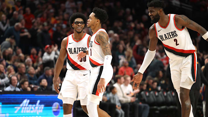 Dec 19, 2023; Portland, Oregon, USA;  Portland Trail Blazers guard Scoot Henderson (00), left, and center Deandre Ayton (2) celebrates with guard Anfernee Simons (1) after Simons scored a basket to seal the 109-104 win over Phoenix Suns at Moda Center. Mandatory Credit: Jaime Valdez-Imagn Images