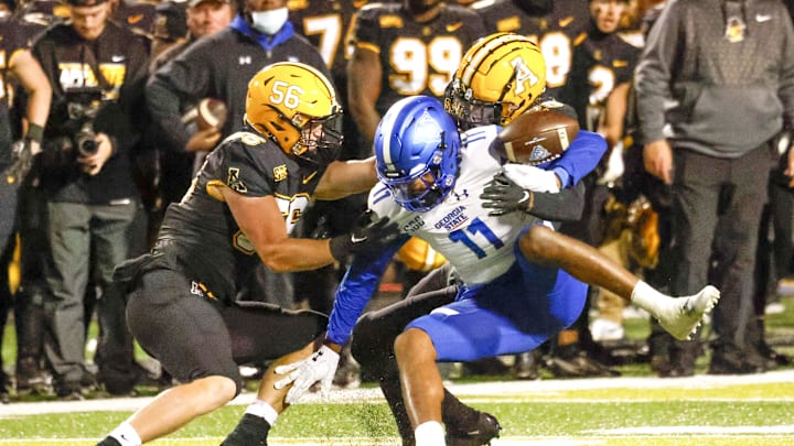Oct 19, 2022; Boone, North Carolina, USA;  Georgia State Panthers wide receiver Cadarrius Thompson (11) fumbles the ball after Appalachian State Mountaineers linebacker Caden Sullivan (26) makes a tackle with Mountaineers linebacker Kyle Arnholt (56) closing in during the second half at Kidd Brewer Stadium. Mandatory Credit: Reinhold Matay-Imagn Images