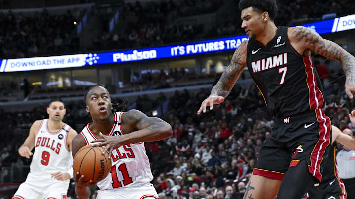 Feb 4, 2025; Chicago, Illinois, USA;  Chicago Bulls guard Ayo Dosunmu (11) moves the ball against Miami Heat center Kel'el Ware (7) during the first half at United Center. Mandatory Credit: Matt Marton-Imagn Images