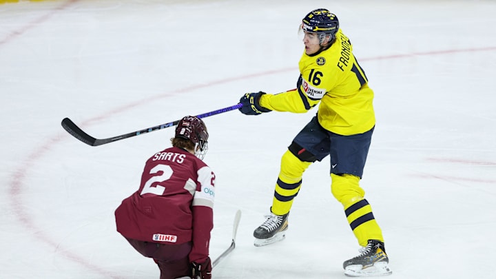 Jan 2, 2026; St. Paul, Minnesota, UNITED STATES; Sweden forward Anton Frondell (16) shoots the puck as Latvia defense Krisjanis Sarts (2) defends during the second period in the quarterfinals of the 2026 IIHF World Junior Championship at Grand Casino Arena. Mandatory Credit: Matt Krohn-Imagn Images Jan 2, 2026; St. Paul, Minnesota, UNITED STATES; Sweden forward Anton Frondell (16) shoots the puck as Latvia defense Krisjanis Sarts (2) defends during the second period in the quarterfinals of the 2026 IIHF World Junior Championship at Grand Casino Arena. Mandatory Credit: Matt Krohn-Imagn Images