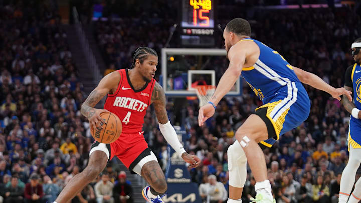 Houston Rockets guard Jalen Green dribbles the ball next to Golden State Warriors guard Stephen Curry.