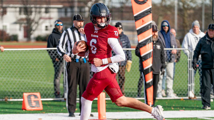 Tabor Academy's quarterback Peter Bourque looks back as he slips into the end zone unchallenged.