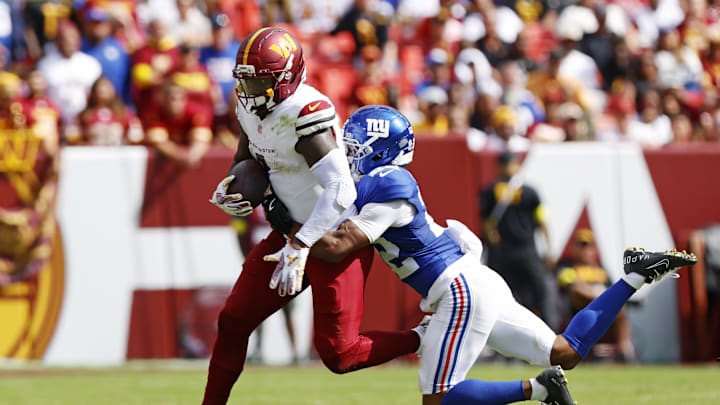 Sep 7, 2025; Landover, Maryland, USA; Washington Commanders wide receiver Deebo Samuel (1) is tackled by New York Giants cornerback Dru Phillips (22) during the fourth quarter at Northwest Stadium.