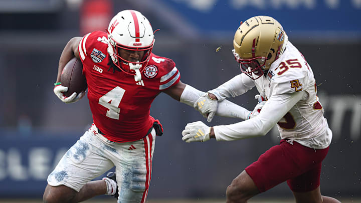 Dec 28, 2024; Bronx, NY, USA; Nebraska Cornhuskers wide receiver Jahmal Banks (4) fights for yards as Boston College Eagles defensive back Ashton McShane (35) tackles during the first half at Yankee Stadium. Mandatory Credit: Vincent Carchietta-Imagn Images