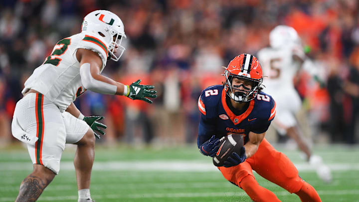 Nov 30, 2024; Syracuse, New York, USA; Syracuse Orange wide receiver Trebor Pena (2) catches the ball against Miami Hurricanes linebacker Raul Aguirre Jr. (32) during the first half at the JMA Wireless Dome. Mandatory Credit: Rich Barnes-Imagn Images