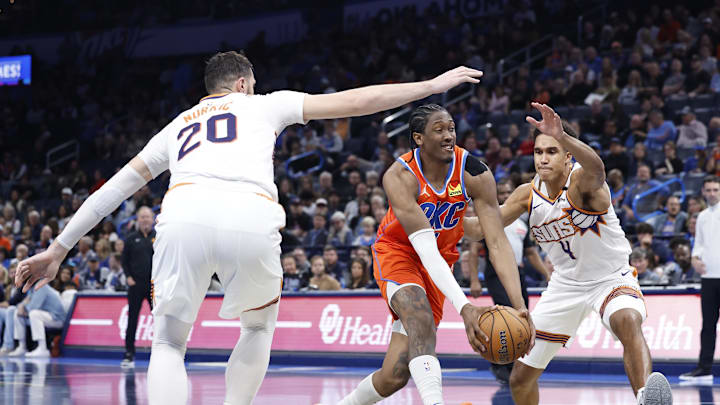 Nov 15, 2024; Oklahoma City, Oklahoma, USA; Oklahoma City Thunder forward Jalen Williams (8) drives to the basket between Phoenix Suns center Oso Ighodaro (4) and center Jusuf Nurkic (20) during the fourth quarter at Paycom Center. Mandatory Credit: Alonzo Adams-Imagn Images