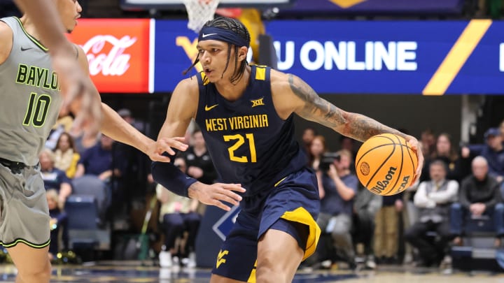West Virginia University guard RaeQuan Battle drives past Baylor guard RayJ Dennis. 