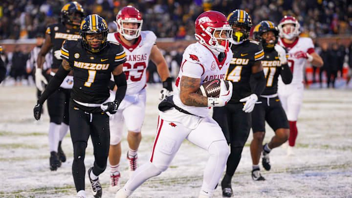 Nov 30, 2024; Columbia, Missouri, USA; Arkansas Razorbacks running back Ja'Quinden Jackson (22) scores a touchdown as Missouri Tigers safety Marvin Burks Jr. (1) looks on during the second half at Faurot Field at Memorial Stadium. Mandatory Credit: Denny Medley-Imagn Images