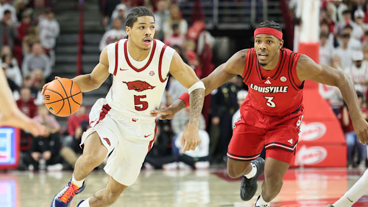 Dec 3, 2025; Fayetteville, Arkansas, USA; Arkansas Razorbacks guard Darius Acuff Jr (5) drives against Louisville Cardinals guard Ryan Conwell (3) during the first half at Bud Walton Arena. Mandatory Credit: Nelson Chenault-Imagn Images