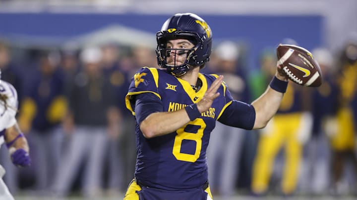 Oct 19, 2024; Morgantown, West Virginia, USA; West Virginia Mountaineers quarterback Nicco Marchiol (8) throws for a touchdown during the fourth quarter against the Kansas State Wildcats at Mountaineer Field at Milan Puskar Stadium. Mandatory Credit: Ben Queen-Imagn Images