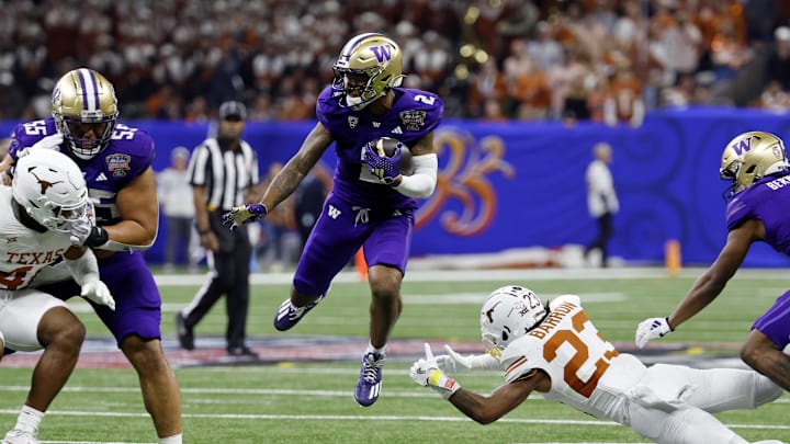 Jan 1, 2024; New Orleans, LA, USA; Washington Huskies wide receiver Ja'Lynn Polk (2) leaps over Texas Longhorns defensive back Jahdae Barron (23) during the third quarter of the 2024 Sugar Bowl college football playoff semifinal game at Caesars Superdome. Mandatory Credit: Geoff Burke-Imagn Images