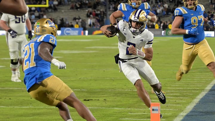 Nov 22, 2025; Pasadena, California, USA;  Washington Huskies quarterback Demond Williams Jr. (2) is forced out of bounds by UCLA Bruins defensive back Cole Martin (21) after a first down during the second half at the Rose Bowl. Mandatory Credit: Jayne Kamin-Oncea-Imagn Images