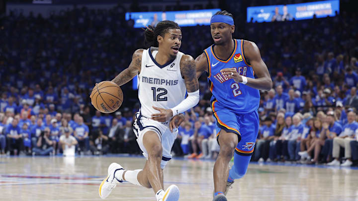 Memphis Grizzlies guard Ja Morant (12) drives to the basket beside Oklahoma City Thunder guard Shai Gilgeous-Alexander (2) in the third quarter during game two of first round for the 2024 NBA Playoffs at Paycom Center. Mandatory Credit: Alonzo Adams-Imagn Images Memphis Grizzlies guard Ja Morant (12) drives to the basket beside Oklahoma City Thunder guard Shai Gilgeous-Alexander (2) in the third quarter during game two of first round for the 2024 NBA Playoffs at Paycom Center. Mandatory Credit: Alonzo Adams-Imagn Images