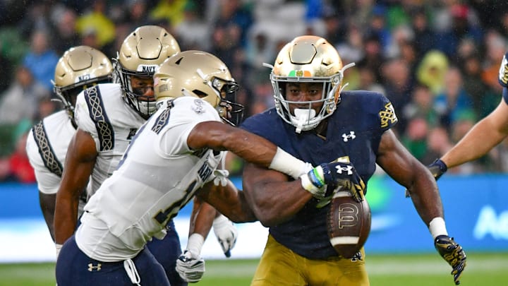 Aug 26, 2023; Dublin, IRL; Navy Midshipmen safety Rayuan Lane III (18) knocks the ball away from Notre Dame Fighting Irish running back Audric Estime (7) in the first quarter at Aviva Stadium. Mandatory Credit: Matt Cashore-Imagn Images Aug 26, 2023; Dublin, IRL; Navy Midshipmen safety Rayuan Lane III (18) knocks the ball away from Notre Dame Fighting Irish running back Audric Estime (7) in the first quarter at Aviva Stadium. Mandatory Credit: Matt Cashore-Imagn Images