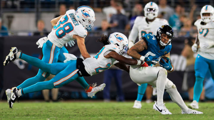 Jacksonville Jaguars wide receiver Elijah Cooks (84) is tackled by Miami Dolphins cornerback Cam Smith (24) during the third quarter of a preseason matchup Saturday, Aug. 26, 2023 at EverBank Stadium in Jacksonville, Fla. The game was suspended in the fourth after Miami Dolphins wide receiver Daewood Davis (87) was injured on a play with the Jaguars leading 31-18.