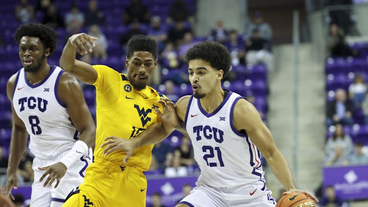 Feb 5, 2025; Fort Worth, Texas, USA; TCU Horned Frogs guard Noah Reynolds (21) controls the ball as West Virginia Mountaineers guard Sencire Harris (10) defends during the first half at Ed and Rae Schollmaier Arena. Mandatory Credit: Kevin Jairaj-Imagn Images Feb 5, 2025; Fort Worth, Texas, USA; TCU Horned Frogs guard Noah Reynolds (21) controls the ball as West Virginia Mountaineers guard Sencire Harris (10) defends during the first half at Ed and Rae Schollmaier Arena. Mandatory Credit: Kevin Jairaj-Imagn Images