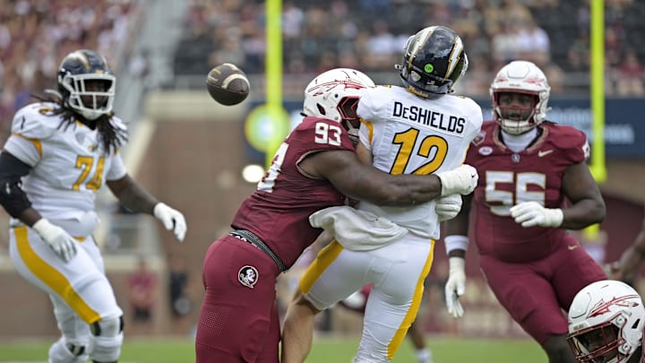 Sep 20, 2025; Tallahassee, Florida, USA; Kent State Golden Flashes quarterback Dru DeShields (12) is hit as he throws the ball by Florida State Seminoles defensive lineman Mandrell Desir (93) during the first half at Doak S. Campbell Stadium. Mandatory Credit: Melina Myers-Imagn Images
