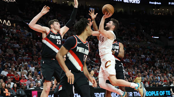 Mar 25, 2025; Portland, Oregon, USA;  Cleveland Cavaliers guard Ty Jerome (2) shoots the ball over Portland Trail Blazers center Donovan Clingan (23) and guard Shaedon Sharpe (17) in the first half at Moda Center. Mandatory Credit: Jaime Valdez-Imagn Images