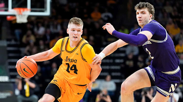 Iowa guard Bennett Stirtz (14) drives toward the basket as Northwestern forward Nick Martinelli (2) defends Feb. 8, 2026 at Carver-Hawkeye Arena in Iowa City, Iowa.