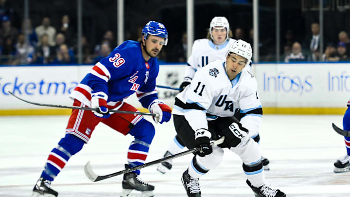 Oct 12, 2024; New York, New York, USA; Utah Hockey Club right wing Dylan Guenther (11) skates with the puck against New York Rangers center Sam Carrick (39) during the first period at Madison Square Garden. Mandatory Credit: John Jones-Imagn Images