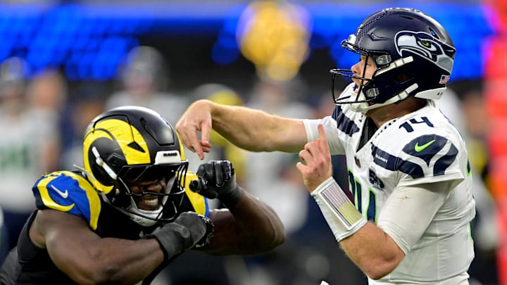 Nov 16, 2025; Inglewood, California, USA;  Seattle Seahawks quarterback Sam Darnold (14) is pressured by Los Angeles Rams linebacker Byron Young (0) at SoFi Stadium. Mandatory Credit: Jayne Kamin-Oncea-Imagn Images