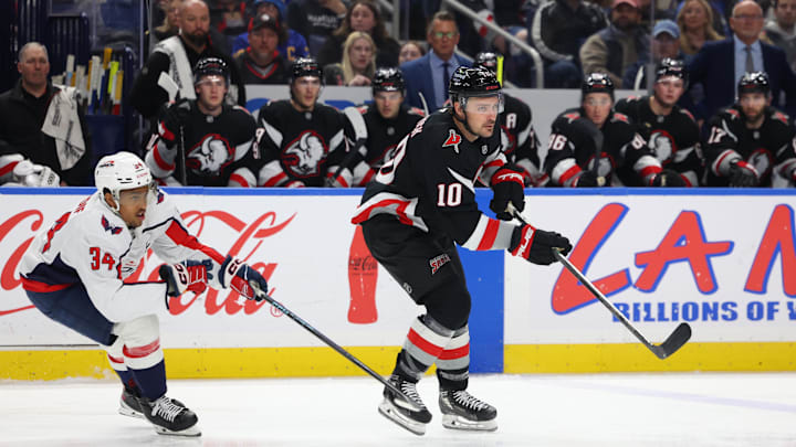 Mar 12, 2026; Buffalo, New York, USA;  Buffalo Sabres center Sam Carrick (10) makes a pass as Washington Capitals center Justin Sourdif (34) defends during the second period at KeyBank Center. Mandatory Credit: Timothy T. Ludwig-Imagn Images