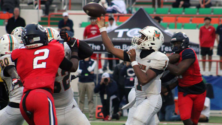 Mandarin quarterback Tramell Jones (1) throws downfield as Miami Columbus edge rushers Dylan