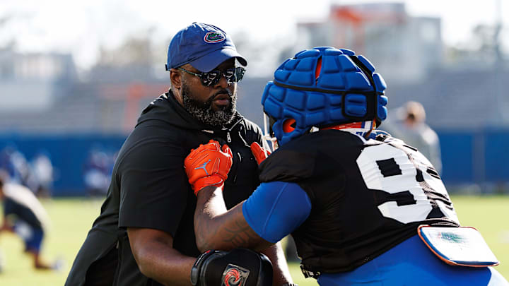Florida Gators assistant coach for defensive line Gerald Chatman participates in a drill with Florida Gators defensive lineman Jamari Lyons (95) during spring football practice at Heavener Football Complex at the University of Florida in Gainesville, FL on Tuesday, March 11, 2025. [Matt Pendleton/Gainesville Sun]