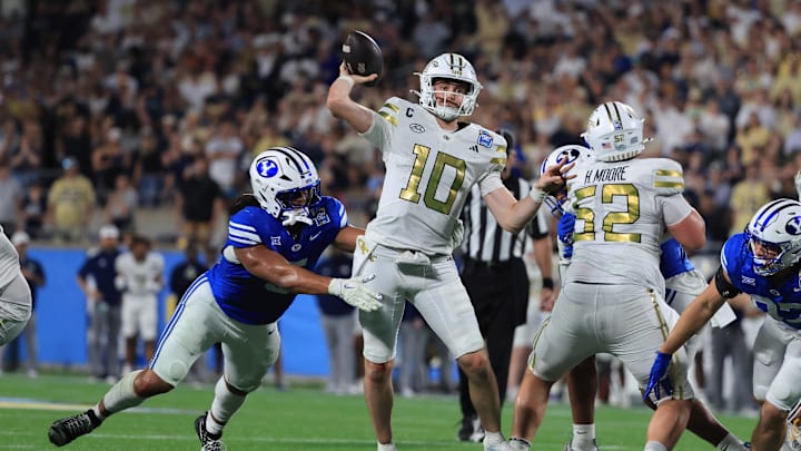 Dec 27, 2025; Orlando, FL, USA; Georgia Tech Yellow Jackets quarterback Haynes King (10) throws the ball as BYU Cougars linebacker Nusi Taumoepeau (5) pressures during the second half at Camping World Stadium. Mandatory Credit: Kim Klement Neitzel-Imagn Images