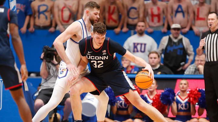 Donovan Clingan drives on Hunter Dickinson during UConn and Kansas's most recent meeting in 2023.