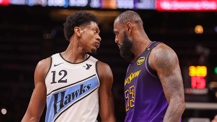 Dec 6, 2024; Atlanta, Georgia, USA; Atlanta Hawks forward De'Andre Hunter (12) is guarded by Los Angeles Lakers forward LeBron James (23) in the fourth quarter at State Farm Arena. Mandatory Credit: Brett Davis-Imagn Images
