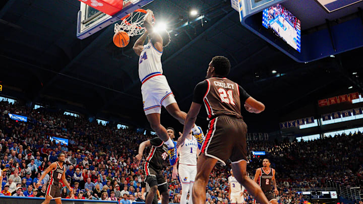 Dec 22, 2024; Lawrence, Kansas, USA; Kansas Jayhawks forward KJ Adams Jr. (24) dunks the ball as Brown Bears guard Aaron Cooley (21) looks on during the second half at Allen Fieldhouse. Mandatory Credit: Denny Medley-Imagn Images