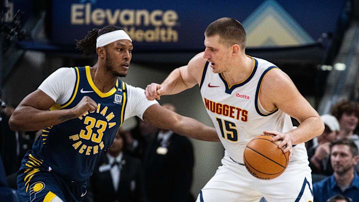 Jan 23, 2024; Indianapolis, Indiana, USA; Denver Nuggets center Nikola Jokic (15) dribbles the ball while Indiana Pacers center Myles Turner (33) defends in the first half at Gainbridge Fieldhouse. Mandatory Credit: Trevor Ruszkowski-Imagn Images