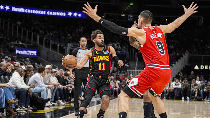Dec 21, 2025; Atlanta, Georgia, USA; Atlanta Hawks guard Trae Young (11) looks to pass against Chicago Bulls center Nikola Vucevic (9) during the first half at State Farm Arena. Mandatory Credit: Dale Zanine-Imagn Images