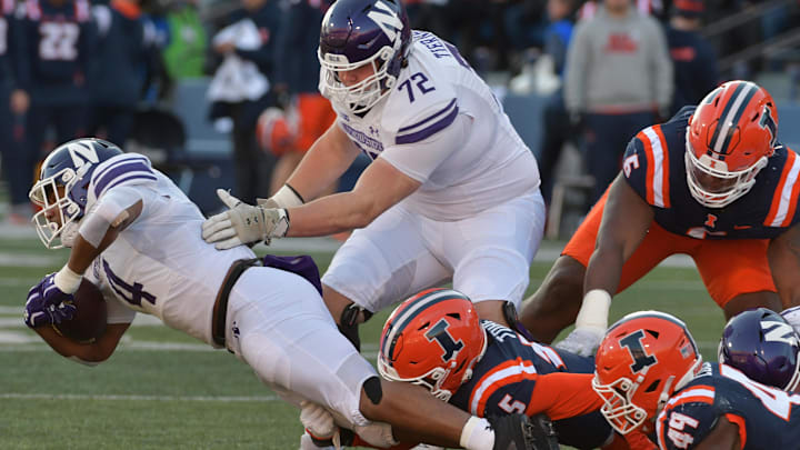 Nov 25, 2023; Champaign, Illinois, USA; Northwestern Wildcats offensive lineman Caleb Tiernan (72) gives a hand to Northwestern Wildcats running back Cam Porter (4) during the first half at Memorial Stadium. Mandatory Credit: Ron Johnson-Imagn Images