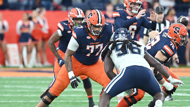 Nov 23, 2024; Syracuse, New York, USA; Syracuse Orange offensive lineman Savion Washington (77) blocks Connecticut Huskies defensive lineman Dal'Mont Gourdine (96) in the first quarter at the JMA Wireless Dome. Mandatory Credit: Mark Konezny-Imagn Images