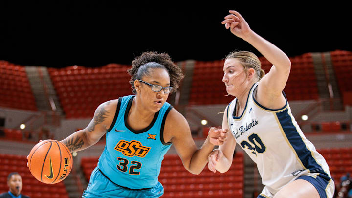 Nov 9, 2025; Stillwater, Oklahoma, USA; Oklahoma State Cowgirls guard Stailee Heard (32) drives to the basket around Oral Roberts Golden Eagles forward Kayten Donley (30) during the second half at Gallagher-Iba Arena. Mandatory Credit: William Purnell-Imagn Images