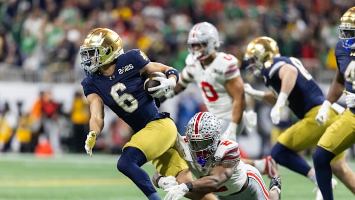 Jan 20, 2025; Atlanta, GA, USA; Notre Dame Fighting Irish wide receiver Jordan Faison (6) runs the ball against Ohio State Buckeyes safety Caleb Downs (2) during the CFP National Championship college football game at Mercedes-Benz Stadium. Mandatory Credit: Mark J. Rebilas-Imagn Images