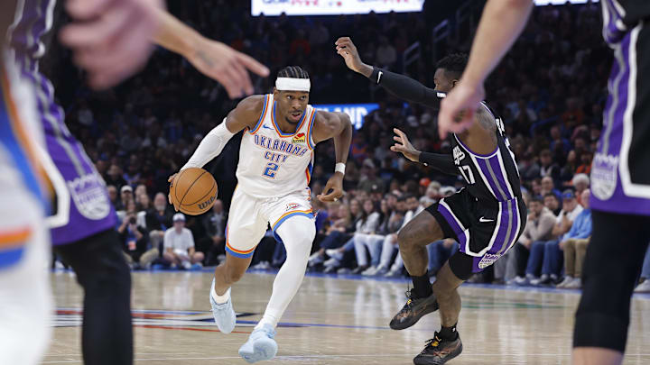 Oct 28, 2025; Oklahoma City, Oklahoma, USA; Oklahoma City Thunder guard Shai Gilgeous-Alexander (2) drives down the court against Sacramento Kings guard Dennis Schroder (17) during the second half at Paycom Center. Mandatory Credit: Alonzo Adams-Imagn Images