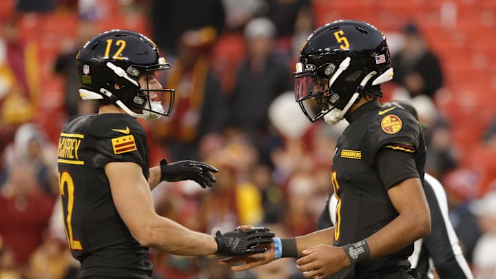 Dec 1, 2024; Landover, Maryland, USA; Washington Commanders quarterback Jayden Daniels (5) celebrates with Commanders wide receiver Luke McCaffrey (12) after defeating the Tennessee Titans at Northwest Stadium. Mandatory Credit: Amber Searls-Imagn Images