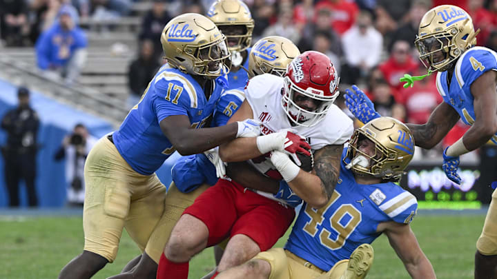 Nov 30, 2024; Pasadena, California, USA; Fresno State Bulldogs tight end Jake Tarwater (87) is tackled by UCLA Bruins linebacker Jalen Woods (17) and defensive back Jaylin Davies (6) and linebacker Carson Schwesinger (49) during the third quarter at Rose Bowl. Mandatory Credit: Robert Hanashiro-Imagn Images