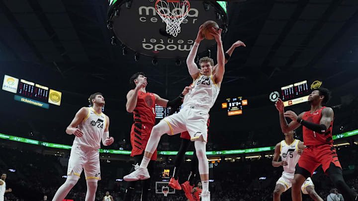 Dec 26, 2024; Portland, Oregon, USA; Utah Jazz power forward Lauri Markkanen (23) grabs a rebound over Portland Trail Blazers forward Toumani Camara (33, behind) during the first half at Moda Center. Mandatory Credit: Soobum Im-Imagn Images