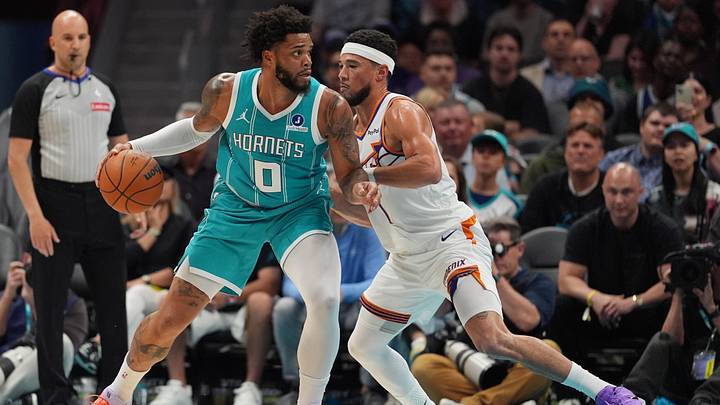 Charlotte Hornets forward Miles Bridges (0) works the ball against Phoenix Suns guard Devin Booker 