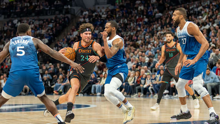 Apr 9, 2024; Minneapolis, Minnesota, USA; Washington Wizards forward Corey Kispert (24) drives into the lane defended by Minnesota Timberwolves guard Mike Conley (10) and guard Anthony Edwards (5) in the second quarter at Target Center. Mandatory Credit: Matt Blewett-Imagn Images