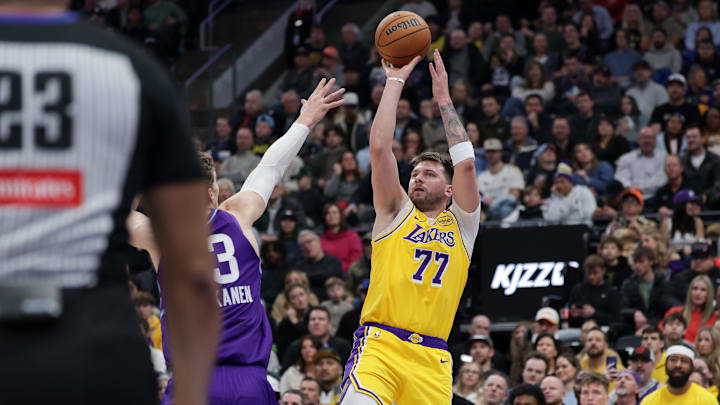 Feb 12, 2025; Salt Lake City, Utah, USA;  Los Angeles Lakers guard Luka Doncic (77) shoots over Utah Jazz forward Lauri Markkanen (23) during the second quarter at Delta Center. Mandatory Credit: Chris Nicoll-Imagn Images